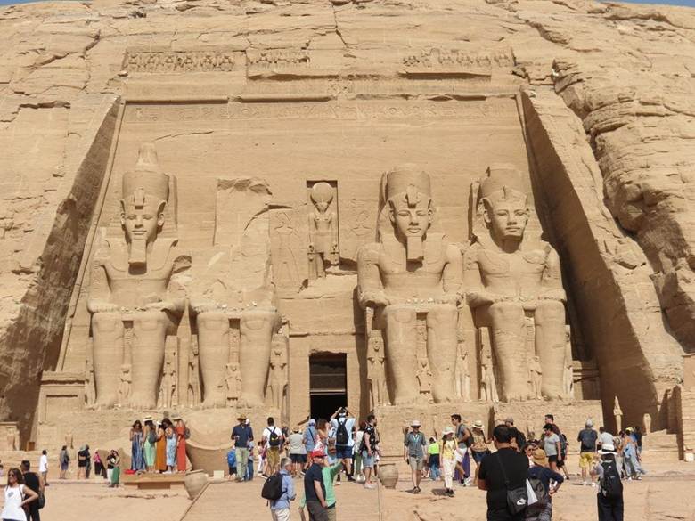 Another entrance at the Abu Simbel complex, showing a small door, flanked by four statues of a seated Ramses II. The image is from Britannica